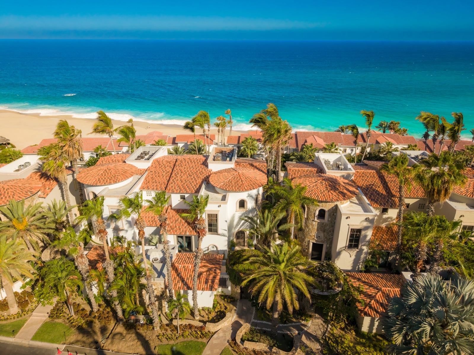 Aerial view of the villa's terracotta rooftops against the turquoise Sea of Cortez and white sand
