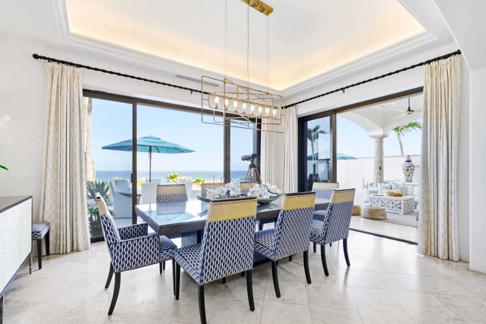 The dining room opening to the terrace, the sea beyond the glass