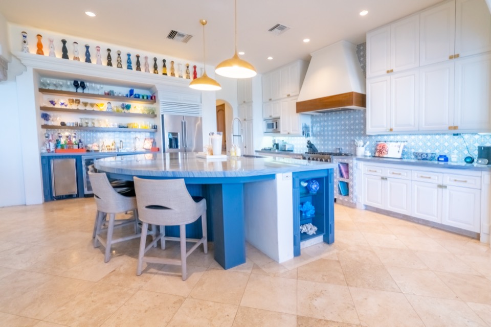 The gourmet kitchen with a blue stone island and open shelving
